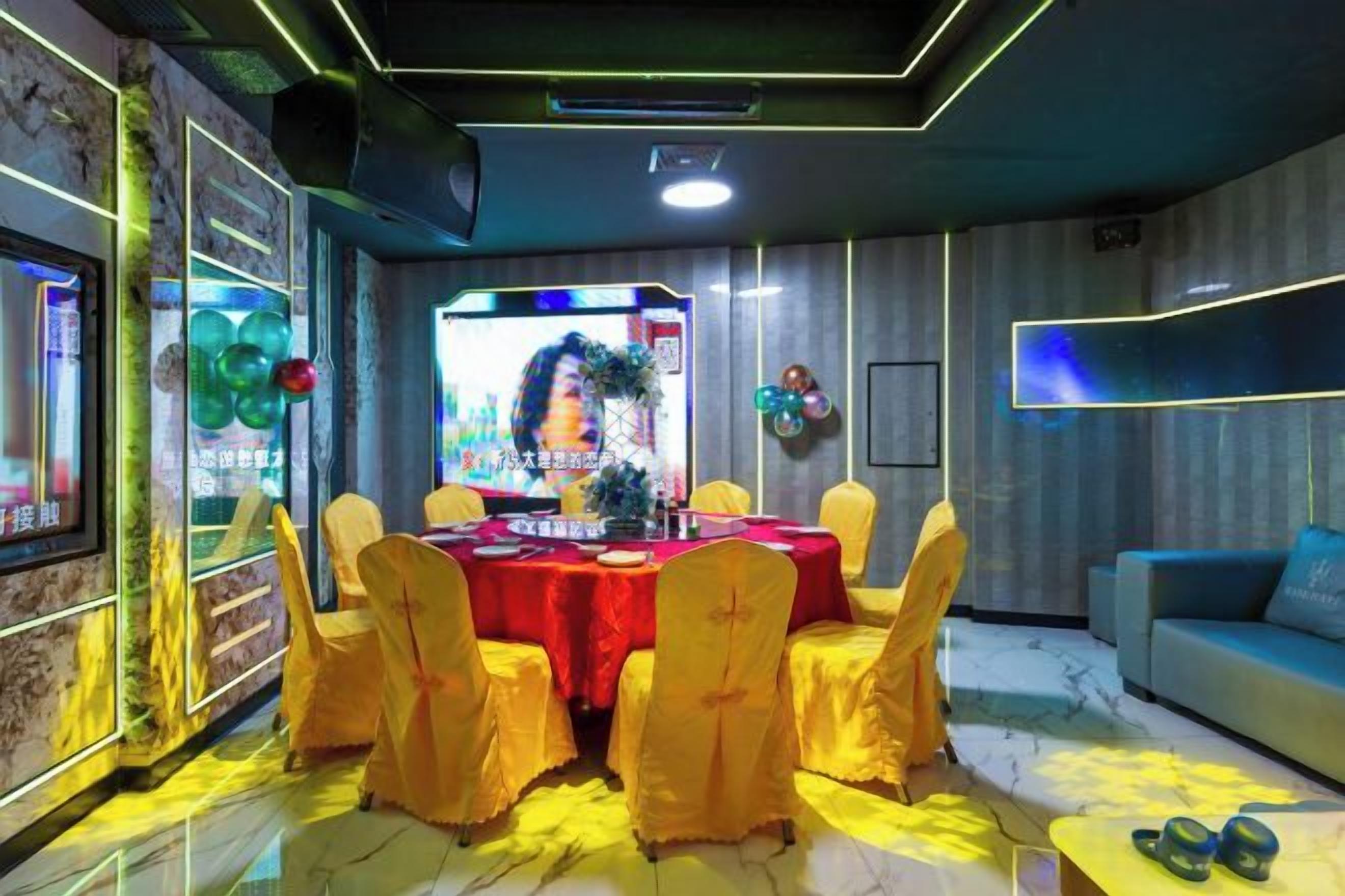 A room with a round table, yellow chairs, and a blue sofa.