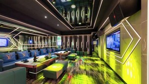 A modern lounge area with seating, a TV, and geometric lighting. - Xiangjiang Hotel Shishi (Shishi)