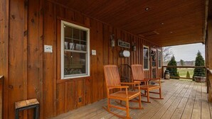 A wooden porch with rocking chairs, a welcome sign, and a view of the surrounding landscape. - Cozy 2BR 2Bath Cabin, minutes from OU, Hocking Hills, Zaleski Forest. (Albany)