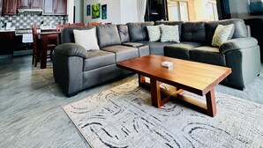 Ein Wohnzimmer mit einer Couch, einem Couchtisch und einem Essbereich mit Stühlen und einem Tisch.