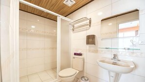 Un bagno con doccia, WC, lavabo e specchio.