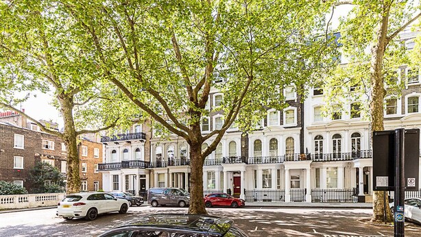 A tree-lined street with parked cars and classic architecture. - Elegant Knightsbridge Flat Near Harrods (London)