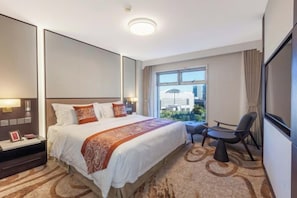 Une chambre d’hôtel avec un grand lit, un bureau et une vue sur la ville.