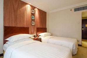 A hotel room with two beds, a wooden headboard, and a wall-mounted picture frame. - Beijing Landmark Hotel (Beijing)