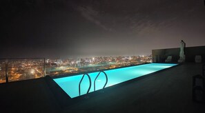 A rooftop pool with a cityscape view at night. - Relax and Work at Miraflores (Lima)