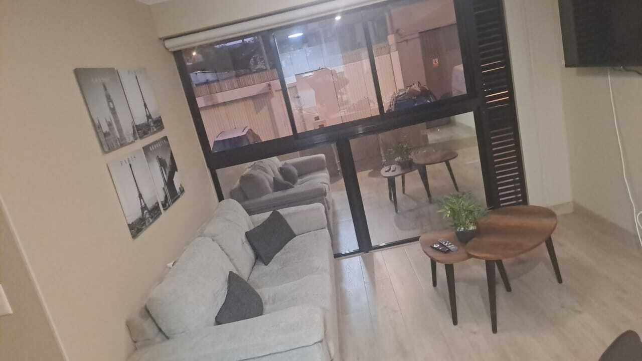 Un salon moderne avec un canapé, une table basse et un téléviseur.