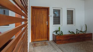 A wooden door with a number 9 sign, a small window, and a planter with plants. - Modern 3-bedroom townhome with a pool, AC and Wi-Fi in vibrant East Legon (Accra)