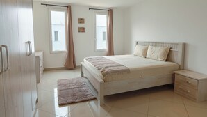 A bedroom with a bed, nightstand, and wardrobe. - Modern 3-bedroom townhome with a pool, AC and Wi-Fi in vibrant East Legon (Accra)