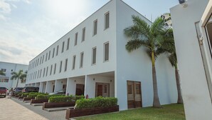 A modern building with multiple windows and a covered walkway. - Modern 3-bedroom townhome with a pool, AC and Wi-Fi in vibrant East Legon (Accra)