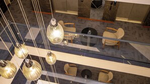 A modern interior with hanging glass chandeliers, a glass railing, and multiple seating areas with chairs. - Rest By Dedeman Elbistan (Elbistan)
