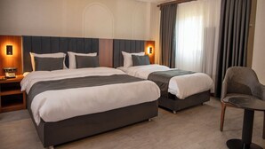 A hotel room with two beds, a chair, and a table. - Rest By Dedeman Elbistan (Elbistan)