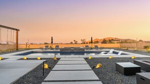 A rooftop pool area with lounge chairs, a fire feature, and a view of mountains. - Bocce, Pool+spa, Game Room, Firepit Modern Oasis Yucca Haven by Avantstay (Yucca Valley)