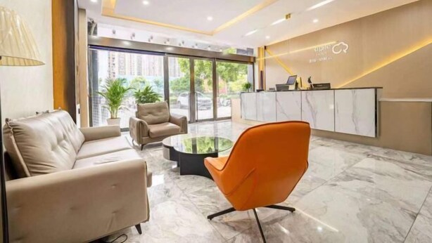 A modern reception area with a sofa, armchairs, a glass coffee table, and a reception desk. - Home Inn Baiyun Hotel (Huai'an Railway Station Mandu Plaza) (Huai'an)