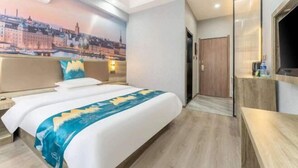 A hotel room with a bed, a wall mural, a TV, and a wooden floor. - Home Inn Baiyun Hotel (Huai'an Railway Station Mandu Plaza) (Huai'an)