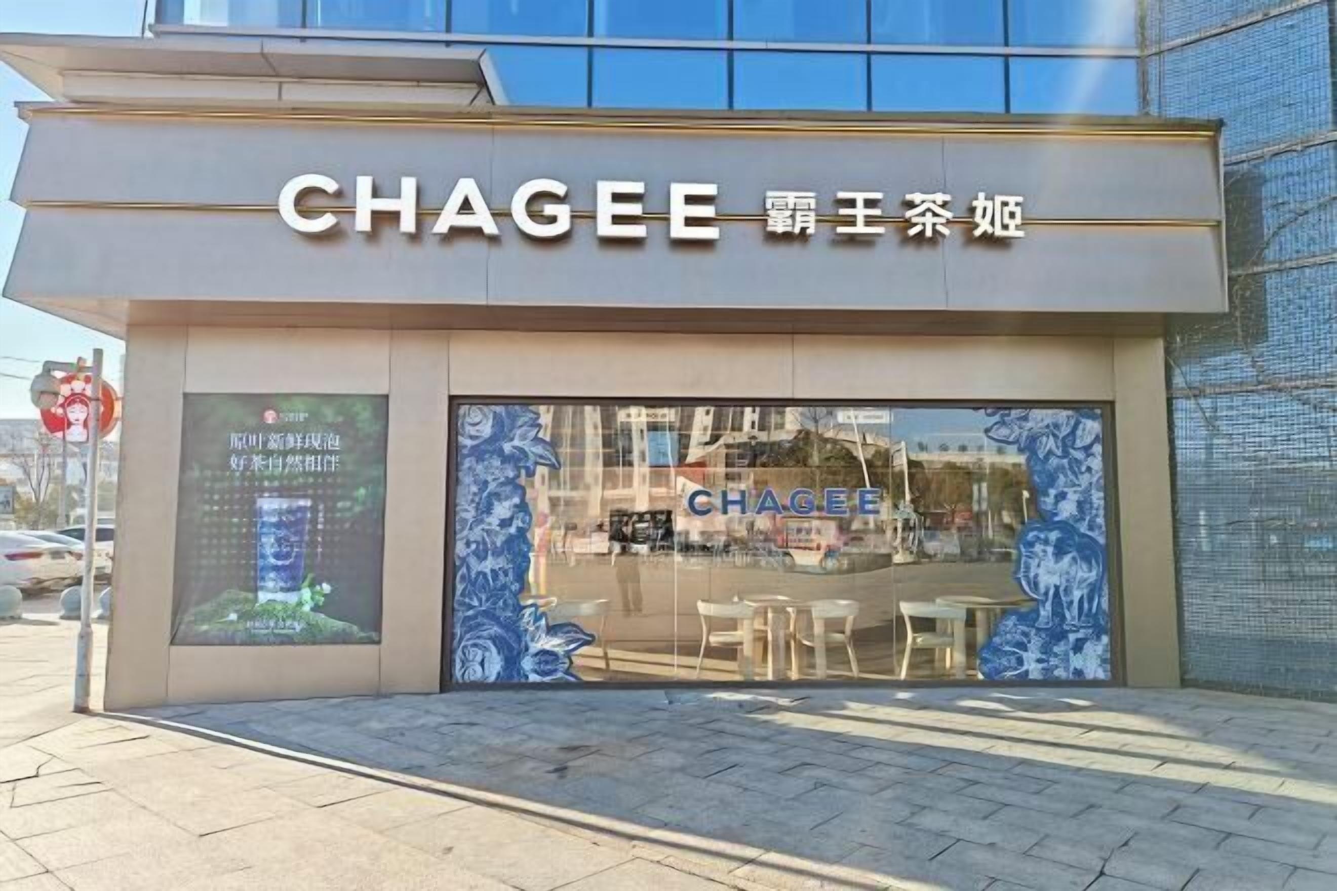 Una tienda Chaggee con fachada moderna, grandes ventanales de vidrio y mesas al aire libre visibles desde la entrada.