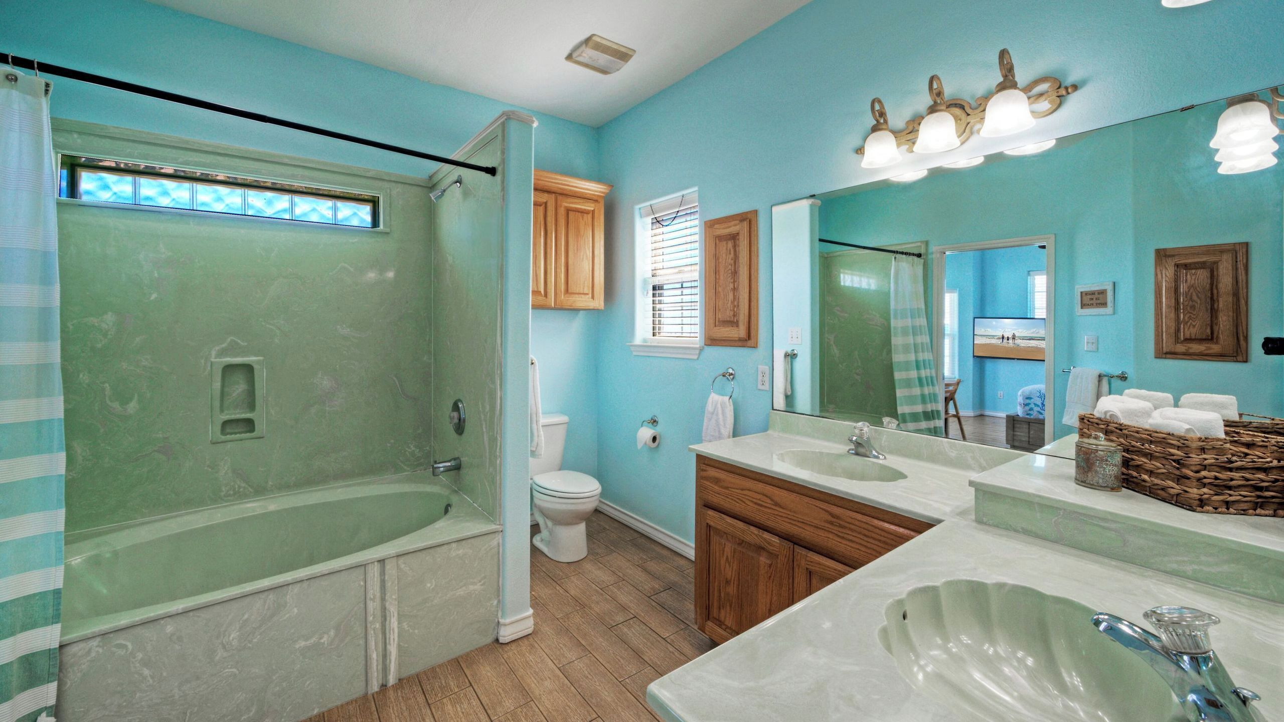 A bathroom with a bathtub, toilet, sink, and vanity.