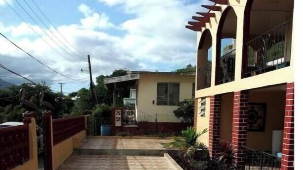 Un edificio a due piani con un vialetto lastricato che conduce all'ingresso.