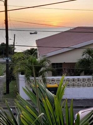 A coastal view with a building and a boat on the water.