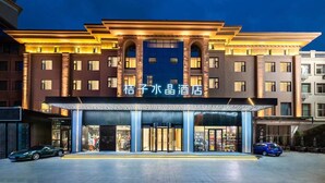 A hotel with a prominent entrance, multiple floors, and a well-lit facade. - Crystal Hotel Qingdao Shilaoren Beach (Qingdao)