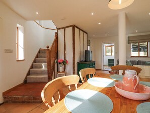 Ein geräumiges Wohnzimmer mit Treppe, Holzmöbeln und einem Fernseher.