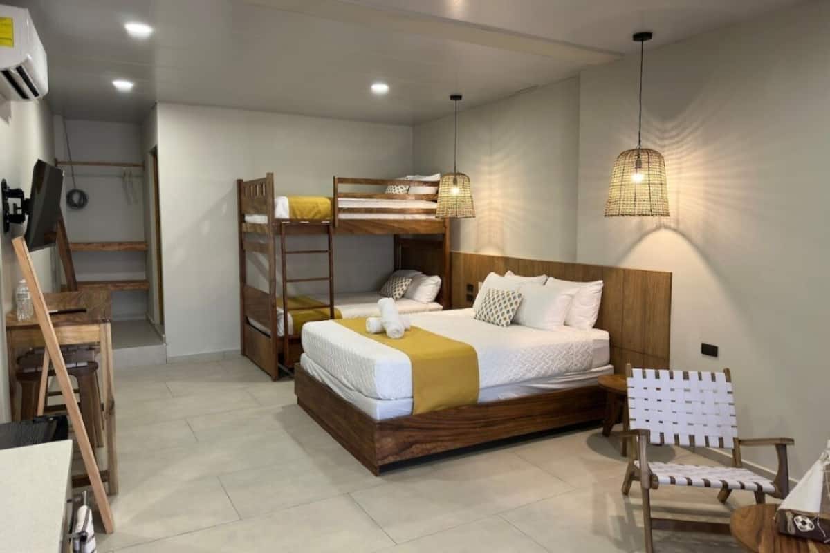 A bedroom with a bunk bed, a desk, and a chair.