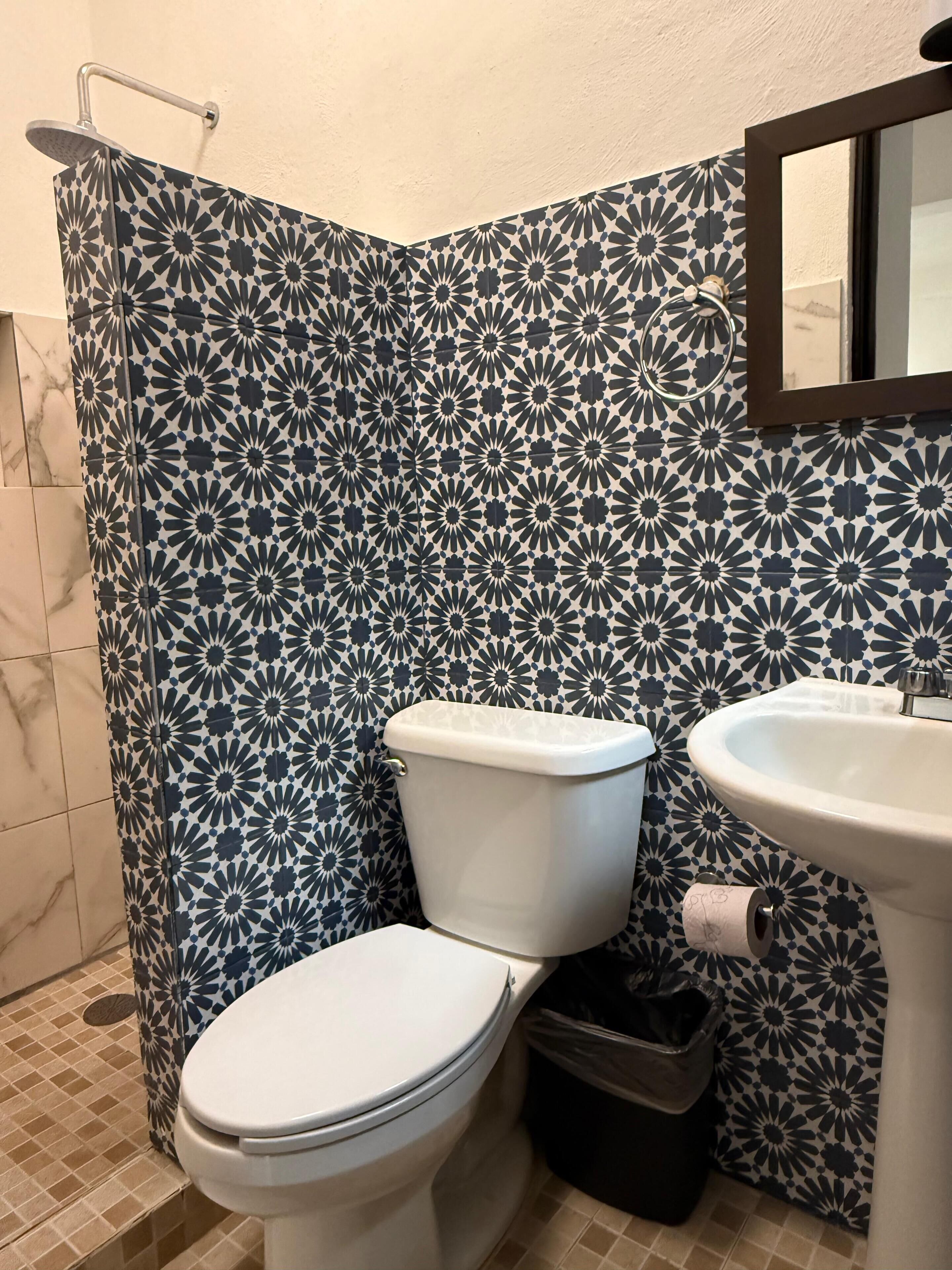 A bathroom with a toilet, sink, and shower.