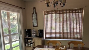 A dining area with a wooden table, chairs, a ceiling fan, and a window with blinds. - Spacious home in Sequoia National Forest (California Hot Springs)