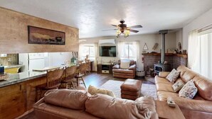 A spacious living room with a fireplace, leather sofas, and a dining area with wooden chairs. - Spacious home in Sequoia National Forest (California Hot Springs)