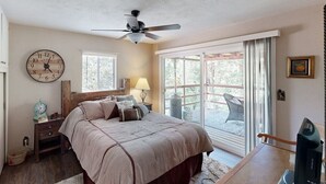 A bedroom with a bed, a ceiling fan, a clock, a window, and a view of the outdoors. - Spacious home in Sequoia National Forest (California Hot Springs)