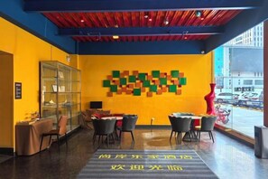 A hotel lobby with a glass display case, a reception desk, and a seating area with chairs and tables. - Shangan Lejia Hotel (Shijiazhuang Railway Station Ximeihua Street) (Shijiazhuang)