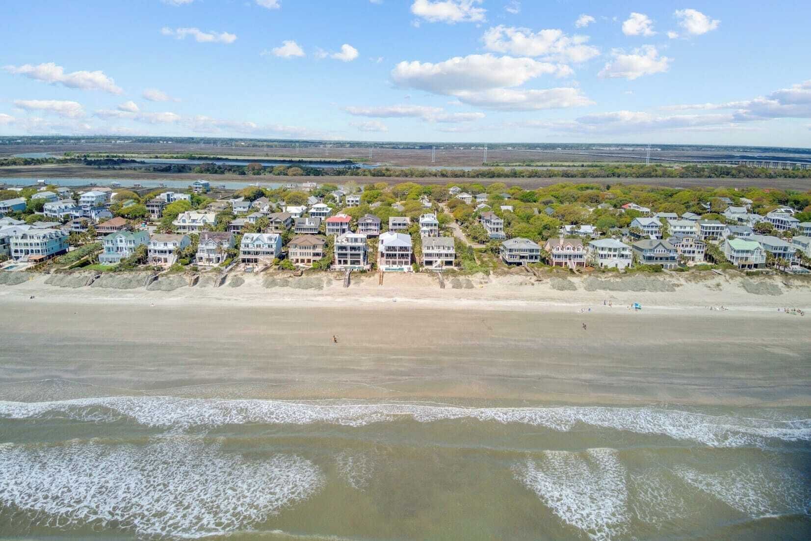 A coastal residential area with beachfront properties, a sandy beach, and a view of the ocean.