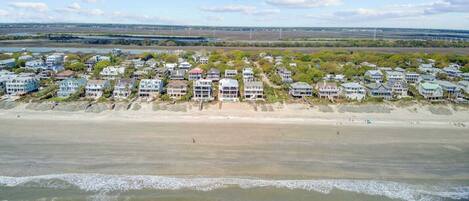 A coastal residential area with beachfront properties, a sandy beach, and a view of the ocean.