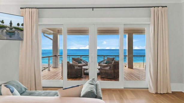 A room with a large sliding glass door leading to a balcony with a view of the ocean. - 712 Ocean Blvd by Avantstay New Construction w/ Pool, Game Zone, Private Beach Access, and Oceanfront Views (Isle of Palms)