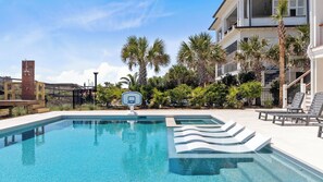 A swimming pool with a basketball hoop, palm trees, and lounge chairs. - 712 Ocean Blvd by Avantstay New Construction w/ Pool, Game Zone, Private Beach Access, and Oceanfront Views (Isle of Palms)