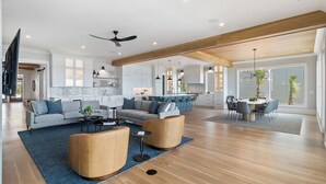 A spacious living area with a sofa, coffee table, and a dining table with chairs. - 712 Ocean Blvd by Avantstay New Construction w/ Pool, Game Zone, Private Beach Access, and Oceanfront Views (Isle of Palms)