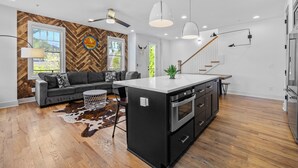 Una cocina moderna con una isla central, horno empotrado y electrodomésticos de acero inoxidable.