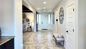 A hallway with a herringbone floor pattern, white walls, and a door with a black handle. - Spacious 5-bedroom house in fabulous Queen Creek with WiFi, AC (Queen Creek)