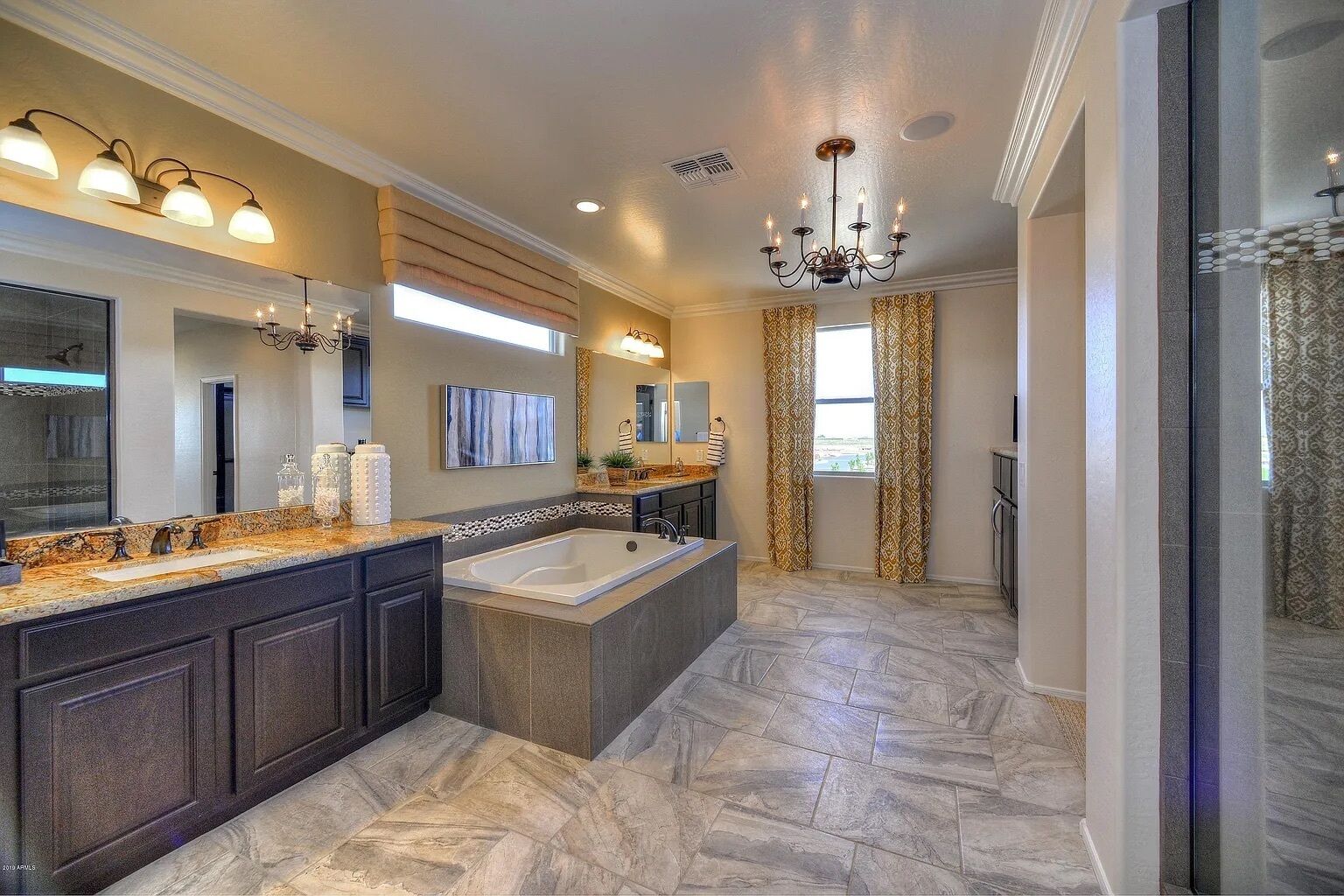 A spacious bathroom with a large vanity, a freestanding bathtub, and a double vanity.