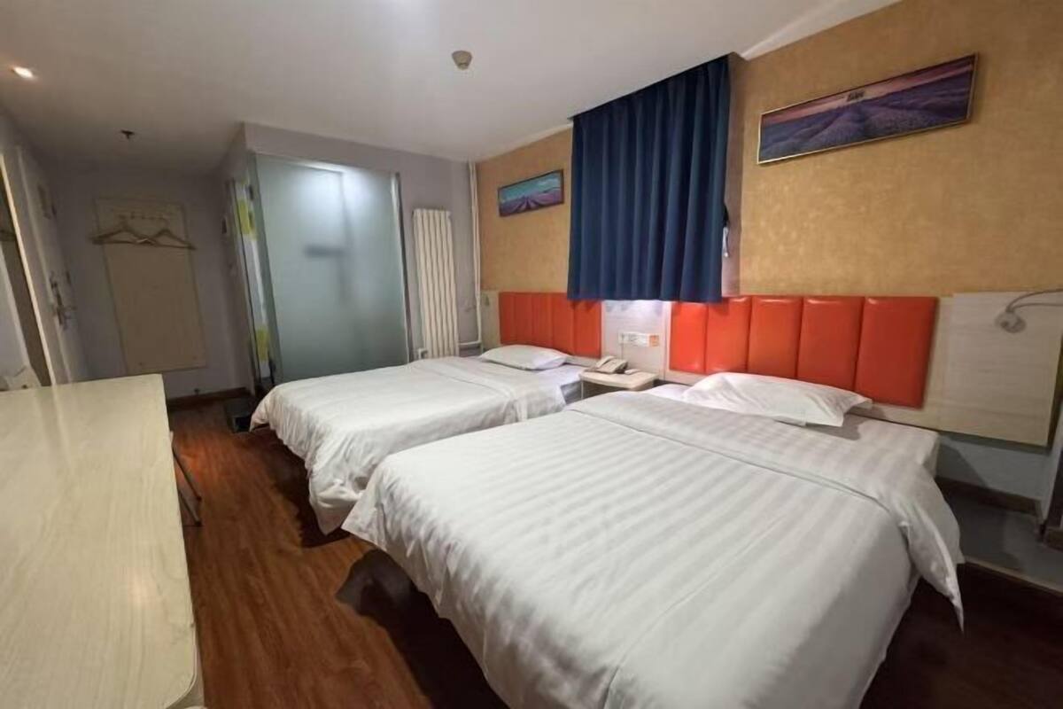 Ein Hotelzimmer mit zwei Betten, einem Schreibtisch und einem Badezimmer.
