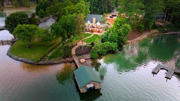 A lakeside property with a dock, a large house, and a smaller building. - Spacious Waterfront Home on Lake Norman With Firepit, Views, and Dock Access (Sherrills Ford)