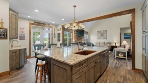 A spacious kitchen with a large island, wooden cabinets, and a chandelier. - Spacious Waterfront Home on Lake Norman With Firepit, Views, and Dock Access (Sherrills Ford)