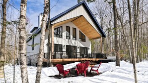 A modern house with a large deck, surrounded by birch trees and snow. - Chamonix Kanata Tremblant (140 Pavillon-Kanata) (Amherst)