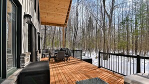 A wooden deck with outdoor furniture, a railing, and a view of a snowy forest. - Chamonix Kanata Tremblant (140 Pavillon-Kanata) (Amherst)