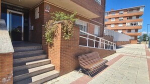 Entrada de un edificio con una escalera que conduce a una puerta con la inscripción 'Via Augusta'.