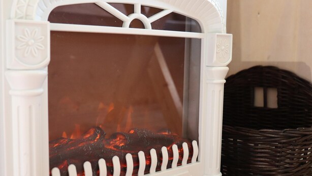 A white fireplace with a glass door and a white picket fence design. - Cabin by Hegermeer With Boat Rentals (Heeg)