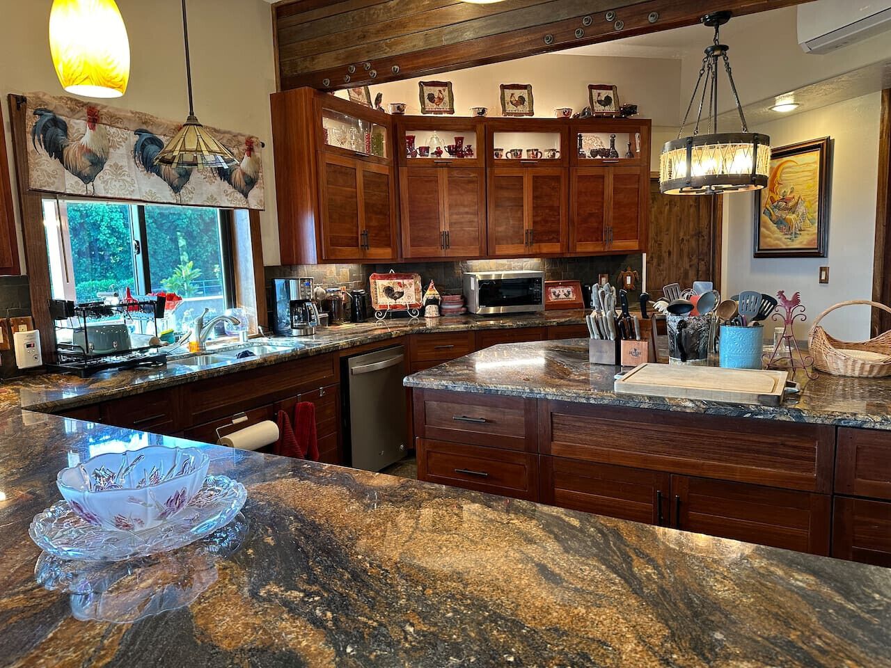 Una cucina con mobili in legno, un piano di lavoro in granito e diversi elettrodomestici.