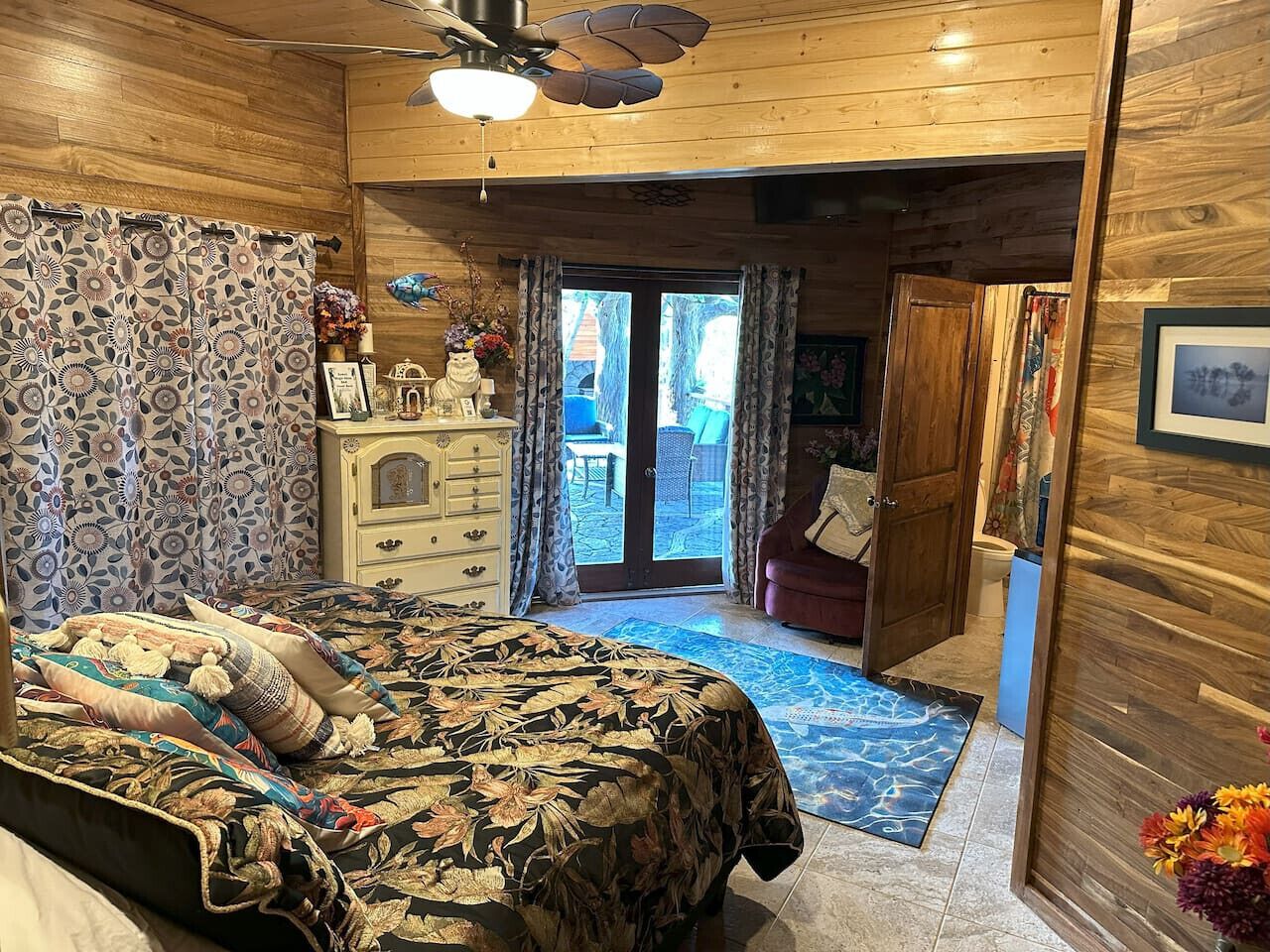 Un dormitorio acogedor con cama, cómoda y vistas al exterior.