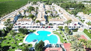 An aerial view of a resort with a central swimming pool, multiple villas, and lush landscaping. - Bungalow by the pool with 2 terraces, maximum capacity for 4 people (Torrevieja)