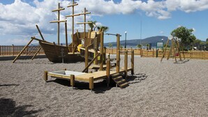 A playground with a pirate ship play structure and a slide. - Comfort Holidays (Messini)