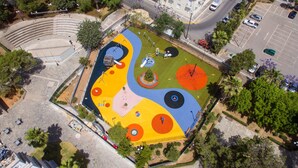 An aerial view of a playground with various play structures and a surrounding landscaped area. - Comfort Holidays (Messini)